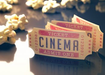 Entry ticket to the cinema with popcorn around. Clipping path included.