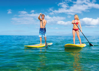 Couple Stand Up Paddle Surfing In Hawaii, Beautiful Tropical Ocean, Active Beach Lifestyle