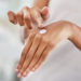 Cropped shot of a woman applying moisturiser to her hands during her morning beauty routine