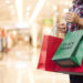 Black Friday, Woman holding many shopping bags while walking in the shopping mall background.