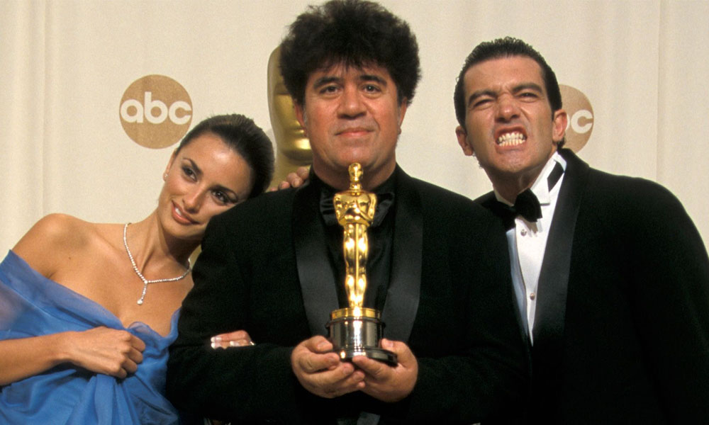 Almodóvar, junto a su primer Oscar y dos amigos.